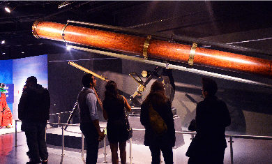 A large wooden telescope as seen in one of the Adler's exhibits.