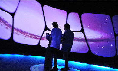 Two children interacting with the A Universe: A Walk Through Space and Time exhibit.