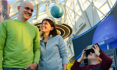 A family of three in the Adler's Solar System exhibit.