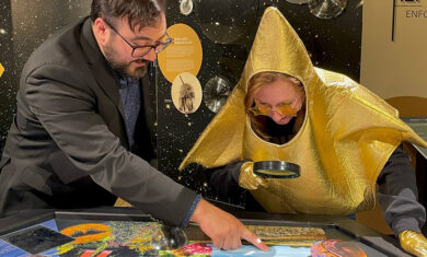 An Adler Educator points out small details that can only be seen through a magnifying lens on the Stargazers Hub table to the Adler Star.