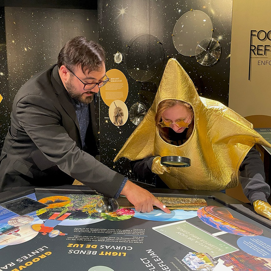 An Adler Educator points out small details that can only be seen through a magnifying lens on the Stargazers Hub table to the Adler Star.