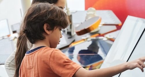Two people interacting with a space exhibit