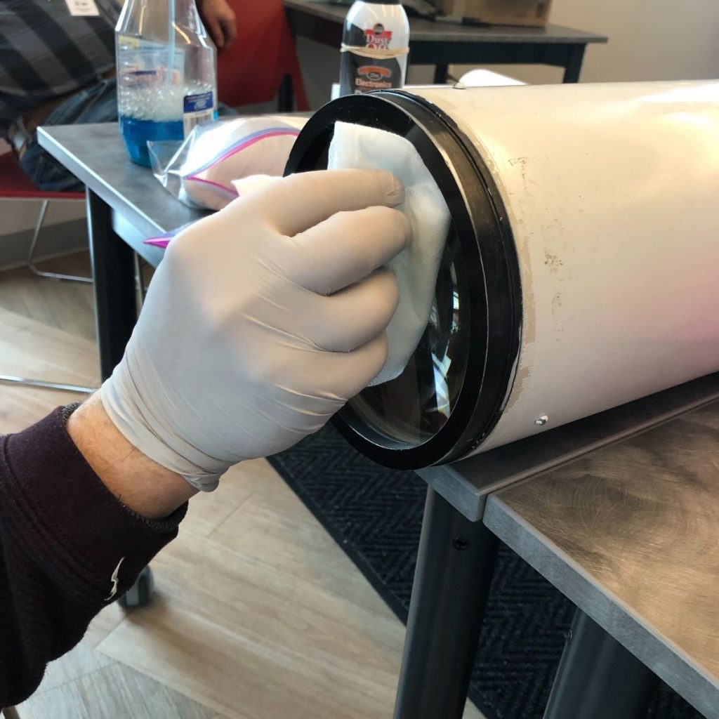 While we’re at it, why not do some additional cleaning? A Chicago Astronomical Society volunteer gives the 6” finderscope lens some cleaning love.