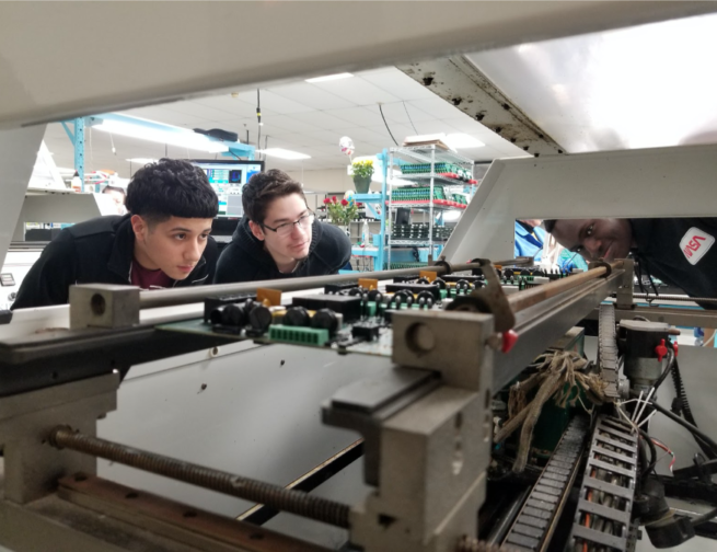 Adler Teens inspect machine in Far Horizons lab.