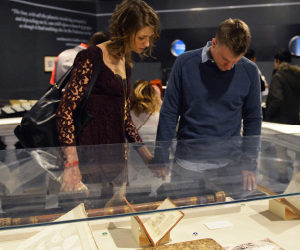 A young couple peers down at a small display of historic astronomy artifacts in the Adler's "Astronomy in Culture" exhibit.