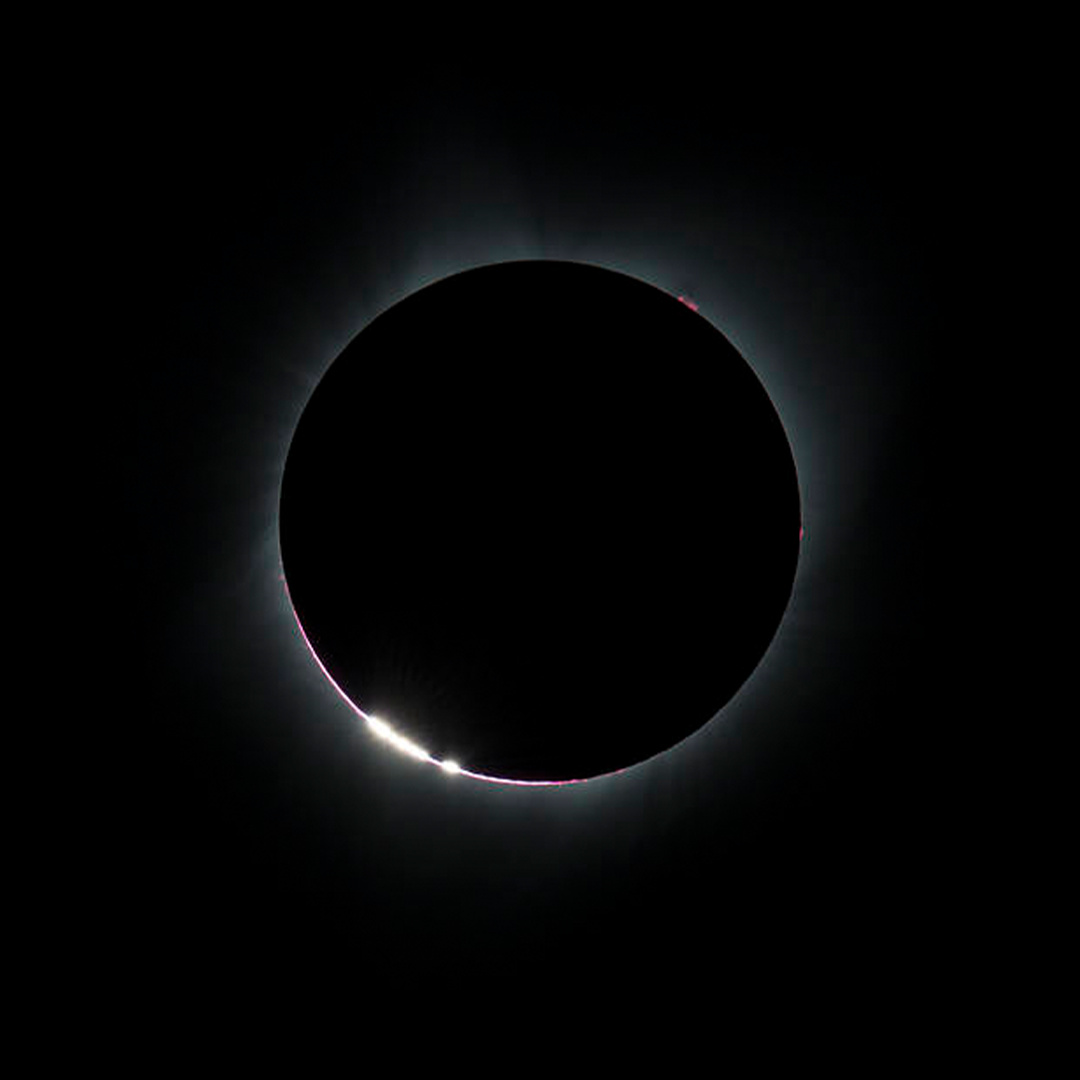 Baily’s Beads are seen on the bottom left corner of the Sun, right before a total solar eclipse in Madras, Oregon, in 2017. Image Credit: NASA/Aubrey Gemignani