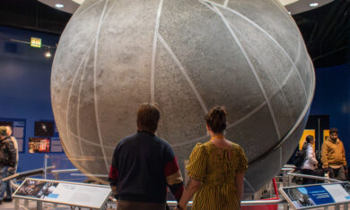 A couple holds hands while looking at the Atwood Sphere in the Adler Planetarium’s exhibit, Chicago’s Night Sky.