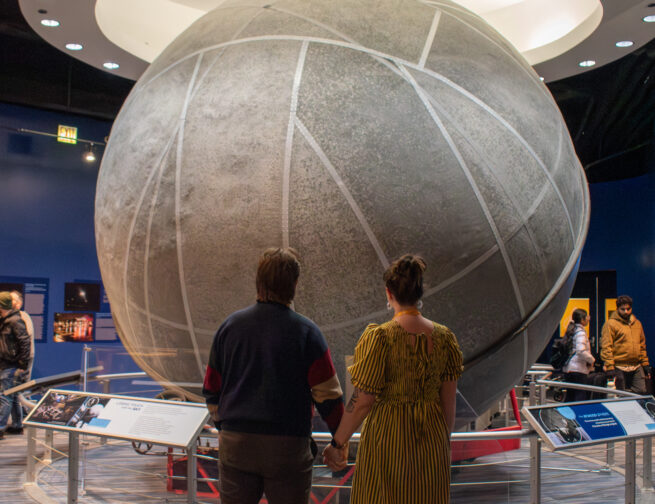 A couple holds hands while looking at the Atwood Sphere in the Adler Planetarium’s exhibit, Chicago’s Night Sky.