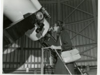 A person looking through the Doane Observatory telescope at the Adler Planetarium