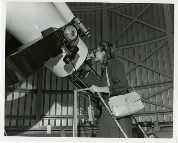 A person looking through the Doane Observatory telescope at the Adler Planetarium