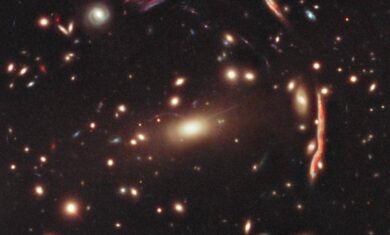 This image depicts a cluster of distorted galaxies. The distorted shapes in the cluster shown here are distant galaxies, from which the light is bent by the gravitational pull of dark matter within the cluster of galaxies.