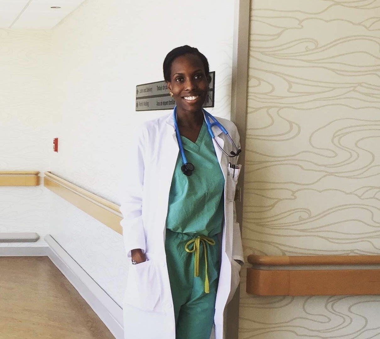 A smiling Choumika poses in her hospital scrubs.