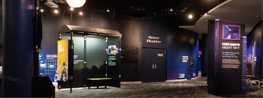 Overview of most of Chicago's Night Sky Exhibit. The room colors are deep blues and purples with grey carpet.