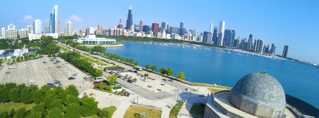 Aerial view of the Adler Planetarium with the Chicago skyline in the background.