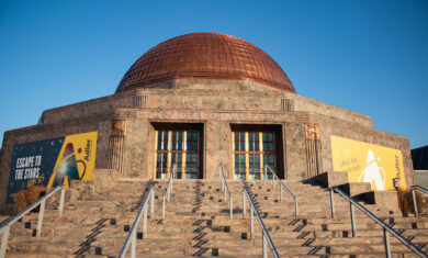 Front exterior of the Adler Planetarium with a blue sky.