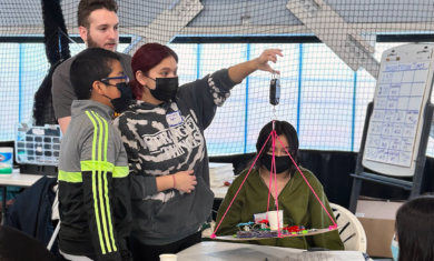 A group of students at the Adler Planetarium's 2023 Operation Airlift, weighing their airship with the guidance of an Adler STEM mentor.