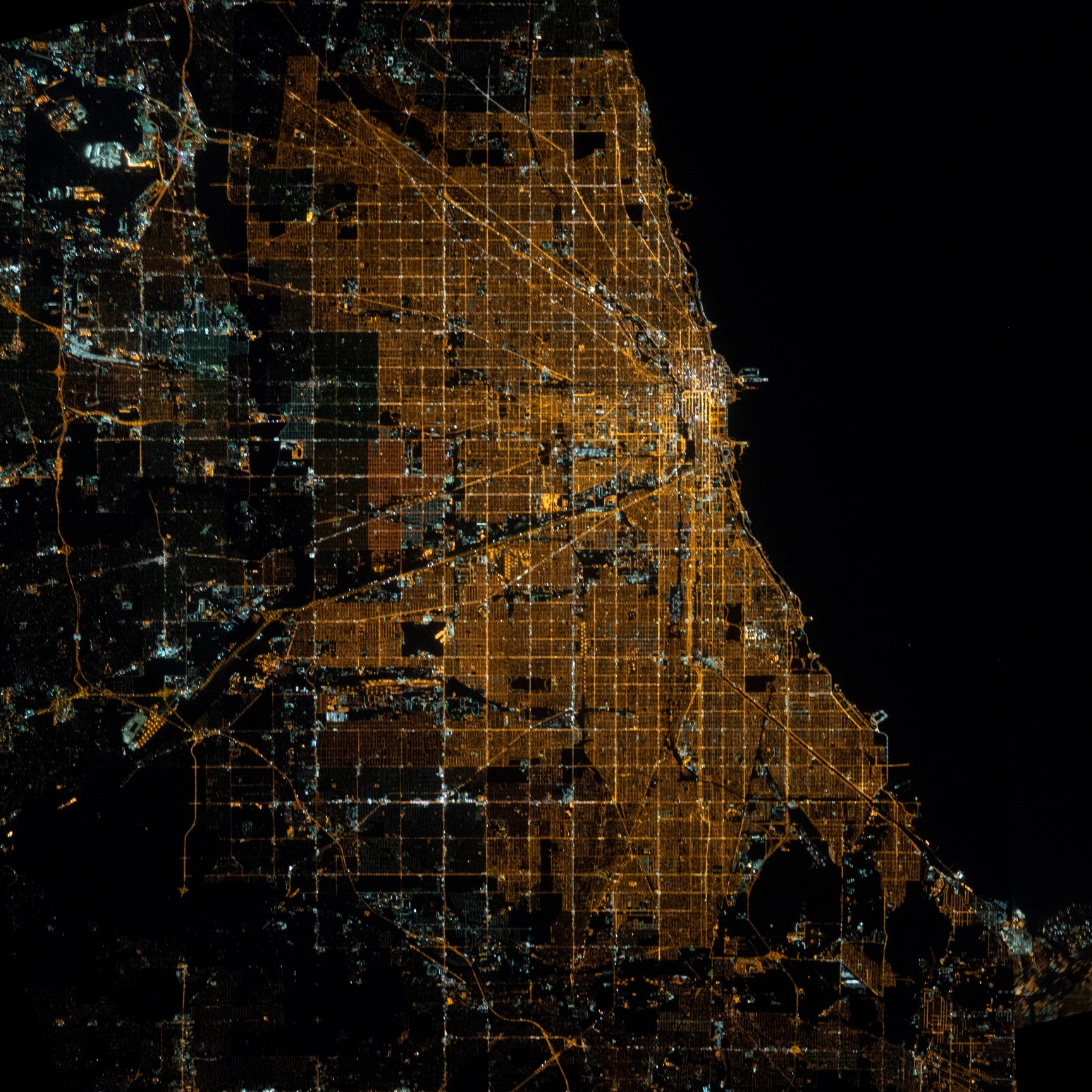 A bird's eye view of Chicago at night, with the city's gridline highly visible.