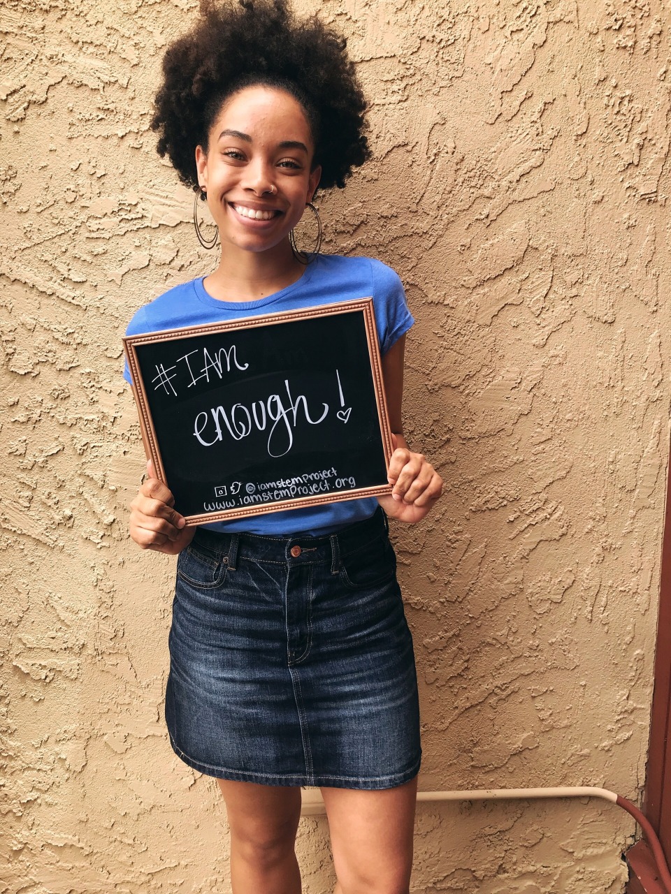 Katrina Miller pictured holding an #IAm Enough sign. 