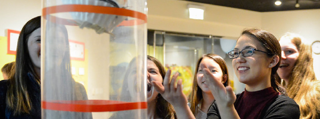 Guests smiling while creating mini-aircraft in one of the Adler's Community Design Labs.