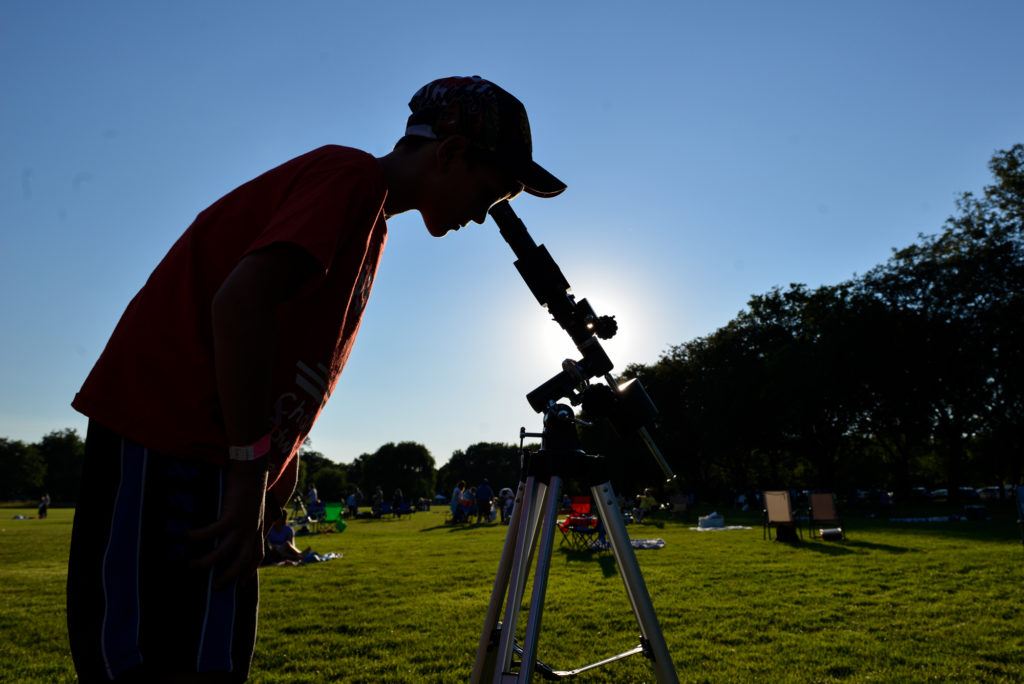 Looking through a telescope at a park.