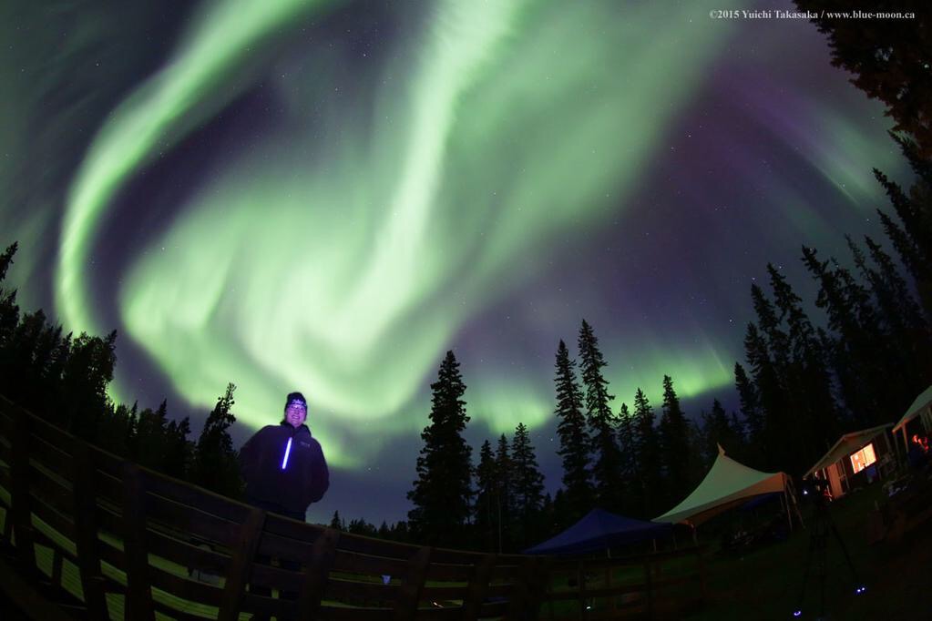 Michelle Nichols standing in front of the Northern Lights at Wood Buffalo National Park, 2015. Photo Credit: Yuichi Takasaka