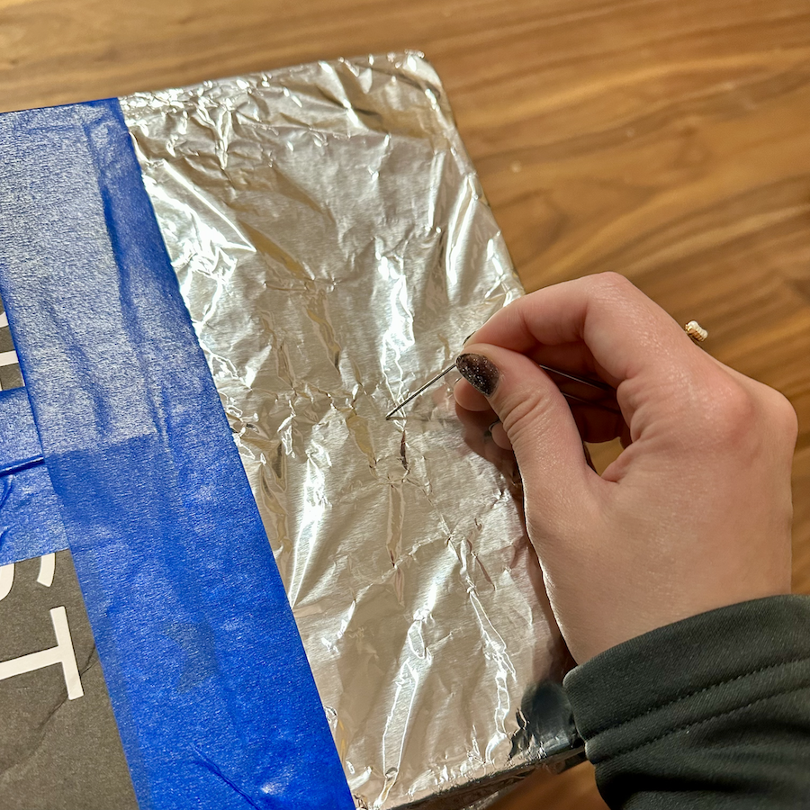 Pinhole projector in progress—a paperclip is used to puncture a small hole in the center of the foil, creating a lens.