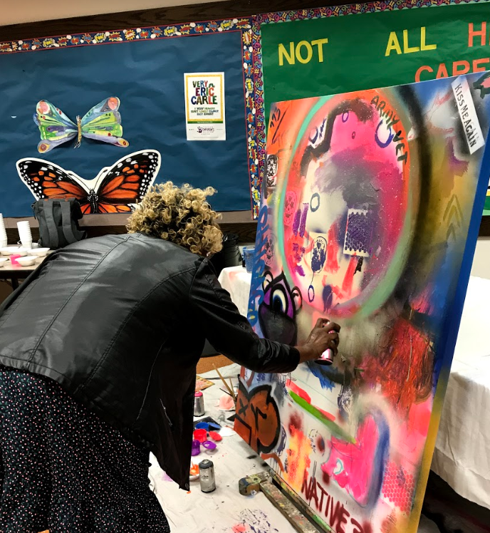 Rita from Humboldt Park paints her name. Her contribution to the Humboldt Park Moonshot Mural.