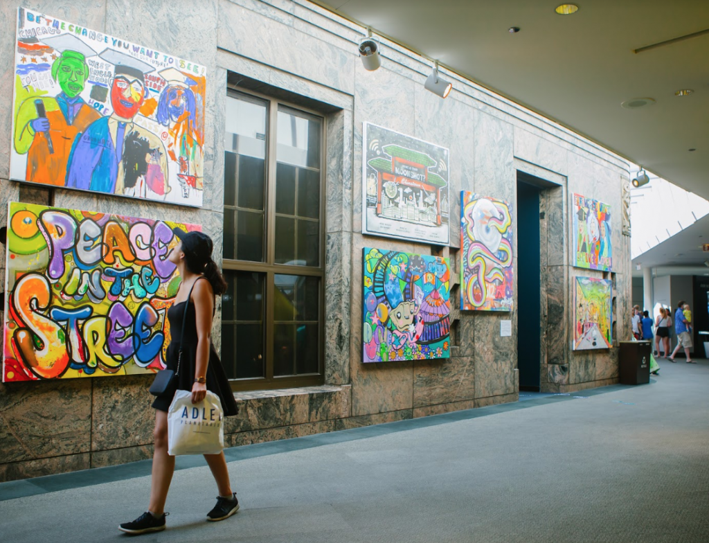 An Adler guest takes in the Chicago Moonshot Murals now on display at the Planetarium.