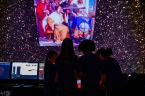 4 Adler Summer Camp campers learn about space visualizations in the Grainger Sky Theater.