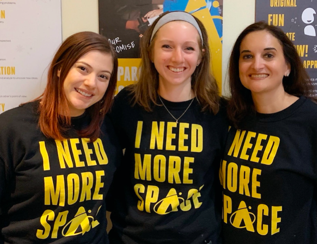 Staff members of the Adler Planetarium marketing team posing with newly branded Adler sweatshirts in January 2020.