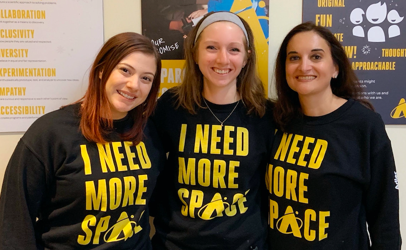 Staff members of the Adler Planetarium marketing team posing with newly branded Adler sweatshirts in January 2020.