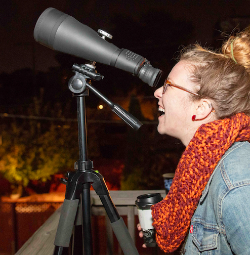 An attendee looking through a telescope during a ‘Scopes In The City neighborhood event with the Adler Planetarium.