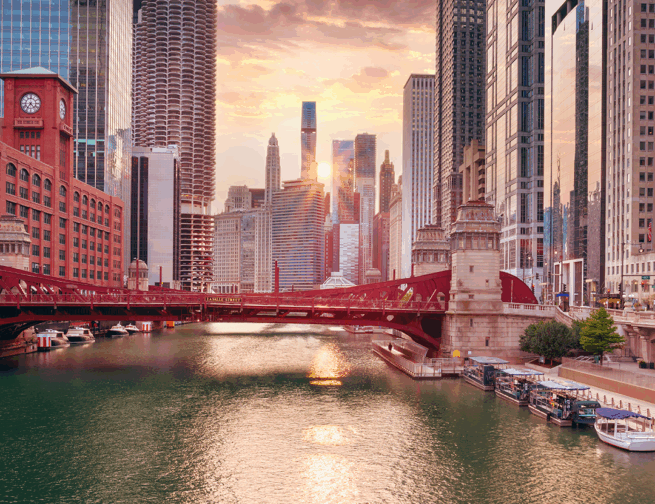 Image of downtown Chicago during the autumn equinox, with the Sun setting in between skyscrapers in the background and the Chicago river in the foreground.