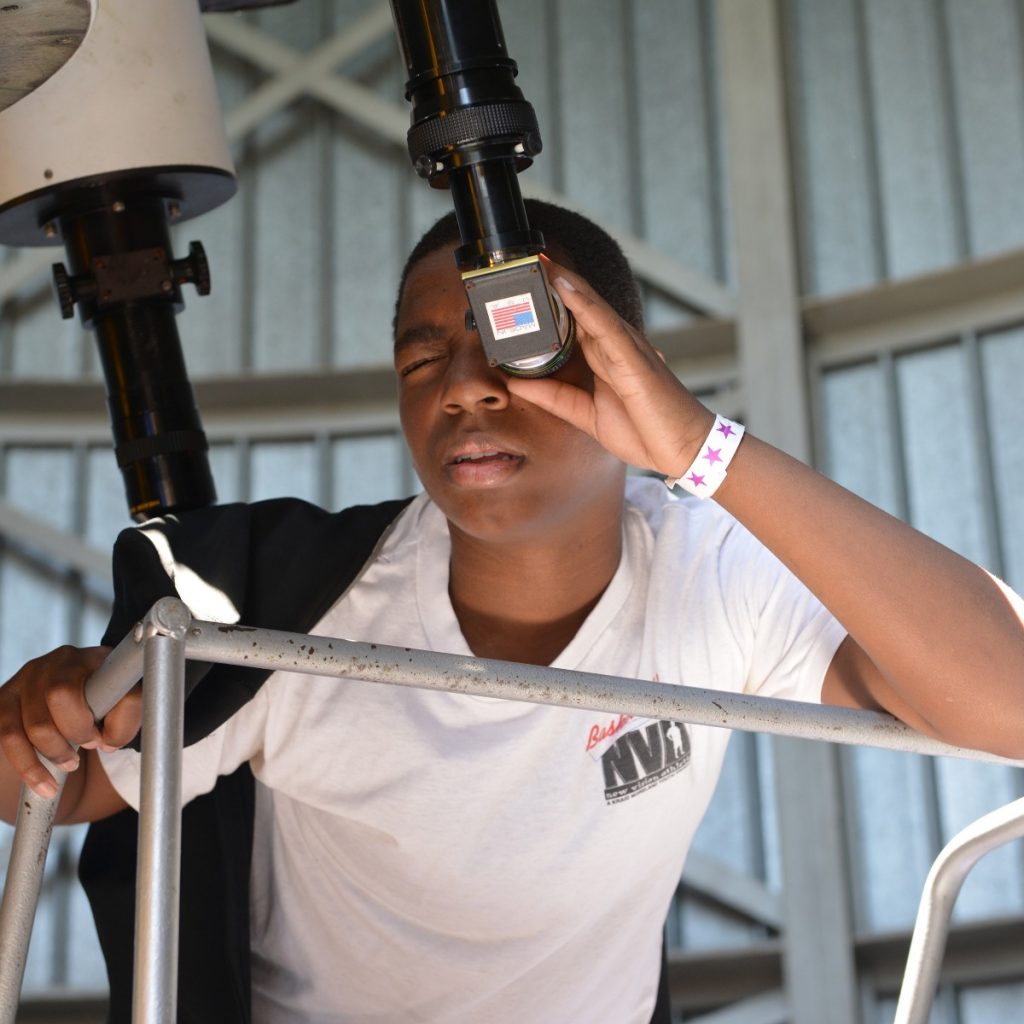 Teen looking through Doane Observatory telescope