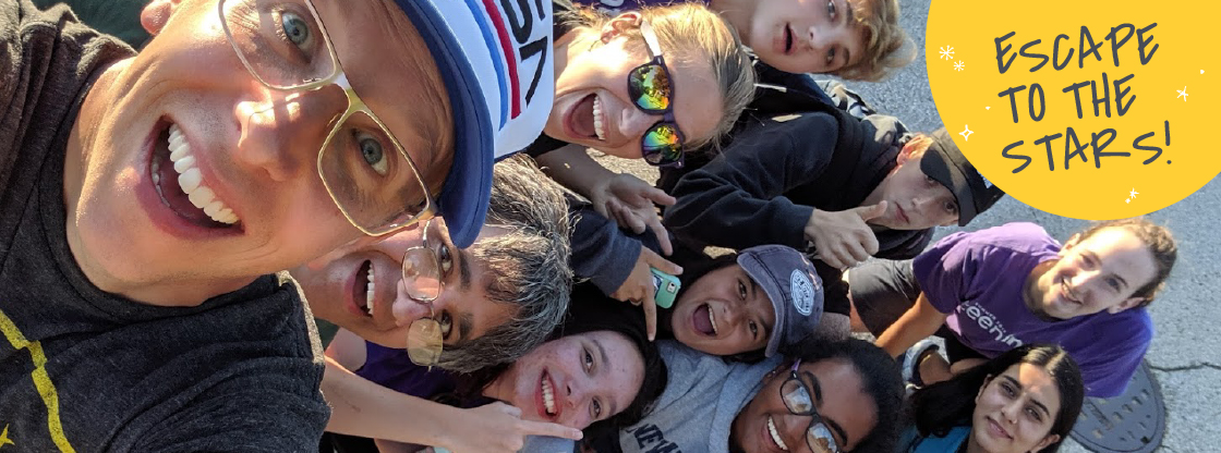 Adler Teen Programs Manager, Chris Bresky, and a group of teens smile while posing for a picture.