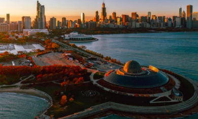 Museum Campus showing an aerial view of the Adler Planetarium, Shedd Aquarium, Field Museum, and Chicago skyline in the fall at sunset.