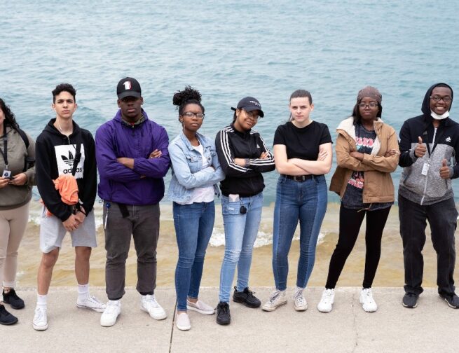 Teen members of the Adler Planetarium's Youth Leadership Council pose for a group photo in front of Lake Michigan.