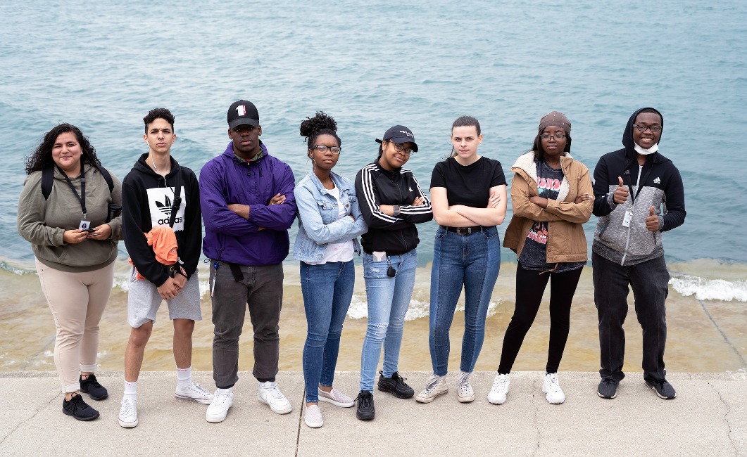 Teen members of the Adler Planetarium's Youth Leadership Council pose for a group photo in front of Lake Michigan.