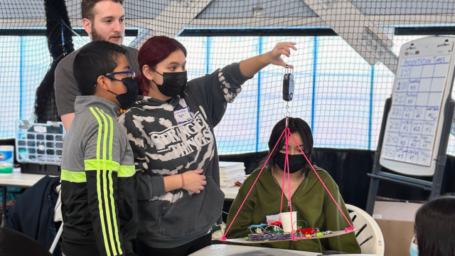 A group of students at the Adler Planetarium’s 2023 Operation Airlift, weighing their airship with the guidance of an Adler STEM mentor.