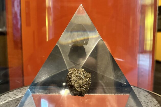 A moon rock on display in a glass pyramid