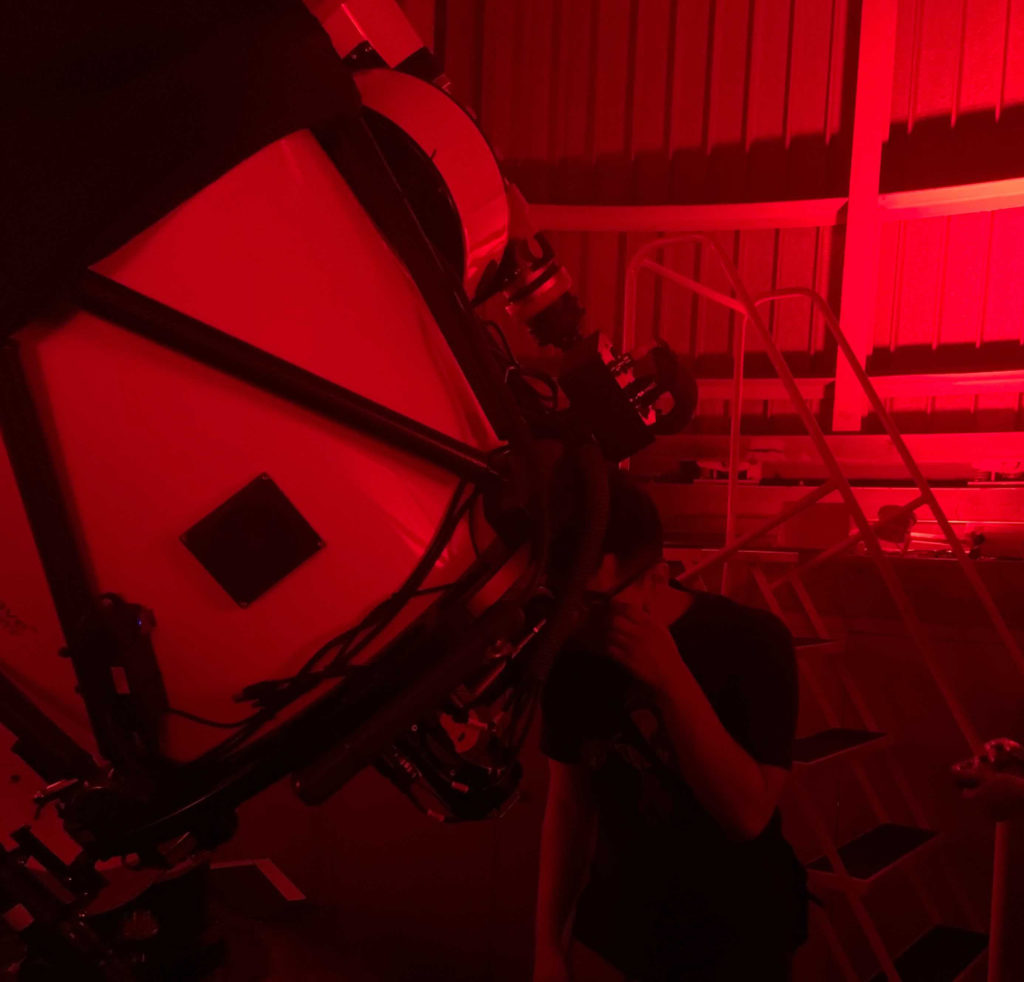 A person observing through a telescope in July 2021 at the 'Scopes at the Adler small-group experience inside the Adler Planetarium's Doane Observatory.