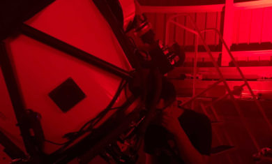 A person observing through a telescope in July 2021 at the 'Scopes at the Adler small-group experience inside the Adler Planetarium's Doane Observatory.