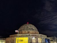 The Adler Planetarium at night with the constellation Orion shining in the sky.