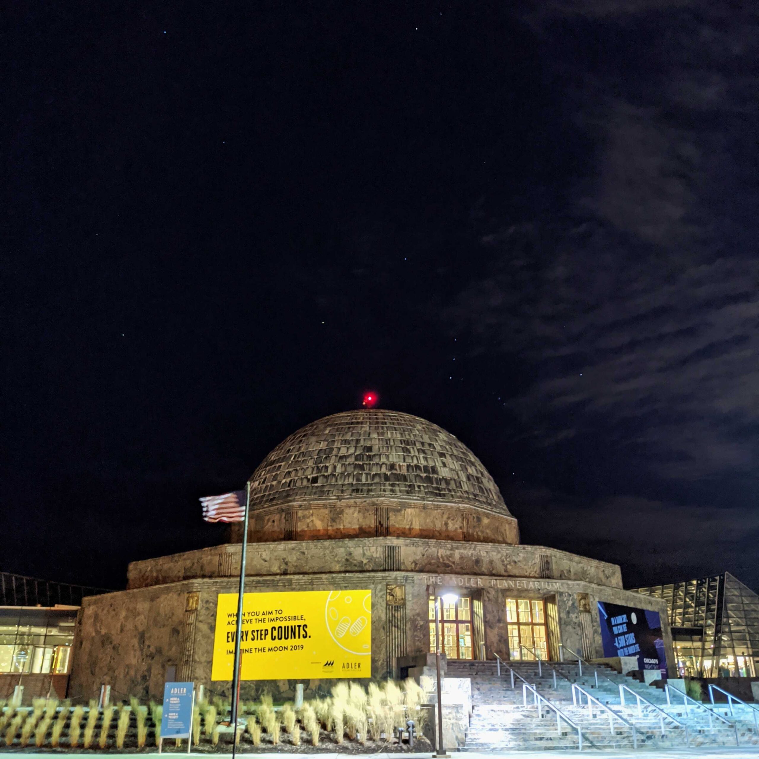 The Adler Planetarium at night with the constellation Orion shining in the sky.