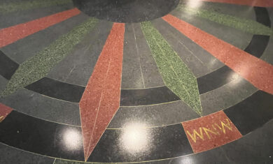 Original 1930 terrazzo floor image with compass rose inset. red, green, black and yellow tones.