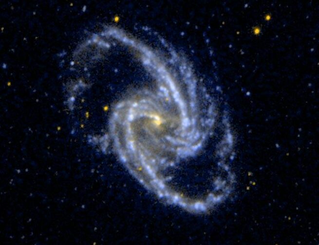 A spiral galaxy with a yellow dot in the center and blue and white dots spiraling out from the center