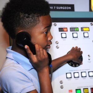 Child using phone in Mission Moon exhibit.
