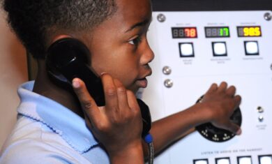 Child using phone in Mission Moon exhibit.
