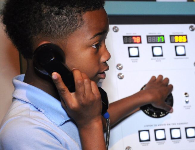 Child using phone in Mission Moon exhibit.