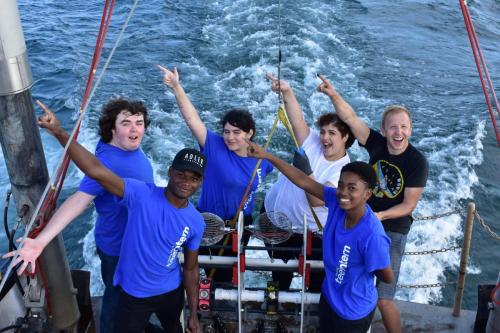 An image of a group of smiling teens on board the Neeskay during a boat excursion for the Adler's "Aquarius Project."